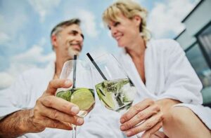 Ein Paar im Bademantel stößt mit einem Cocktail an