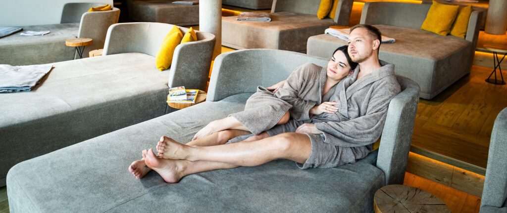 Paar auf Ruhesofe genießt eine unserer Pauschalen unseres Adults Only Wellnesshotel in Bayern