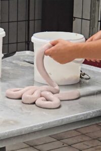 Echtes Handwerk - Der Chaf an der Wurstspritze in der Metzgerei unseres Wellnesshotel